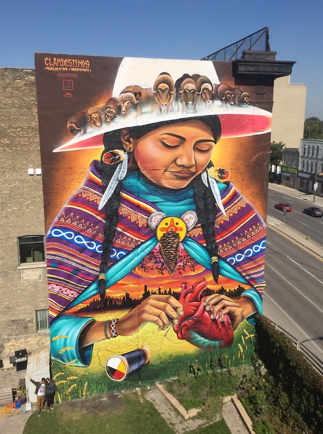 “Mending” at the Corner of Main Street and Sutherland in Winnipeg. Artists: Clandestinos (Shalak Attack & Bruno Smoky, 2017)