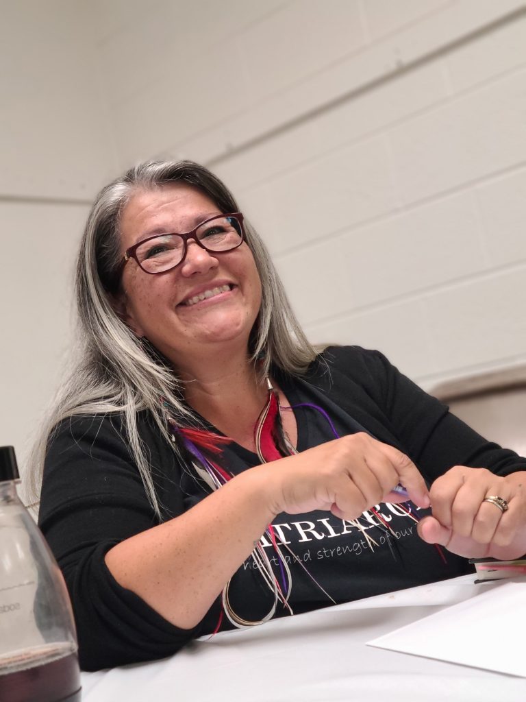 Image of Patty as she sits at a desk smiling.